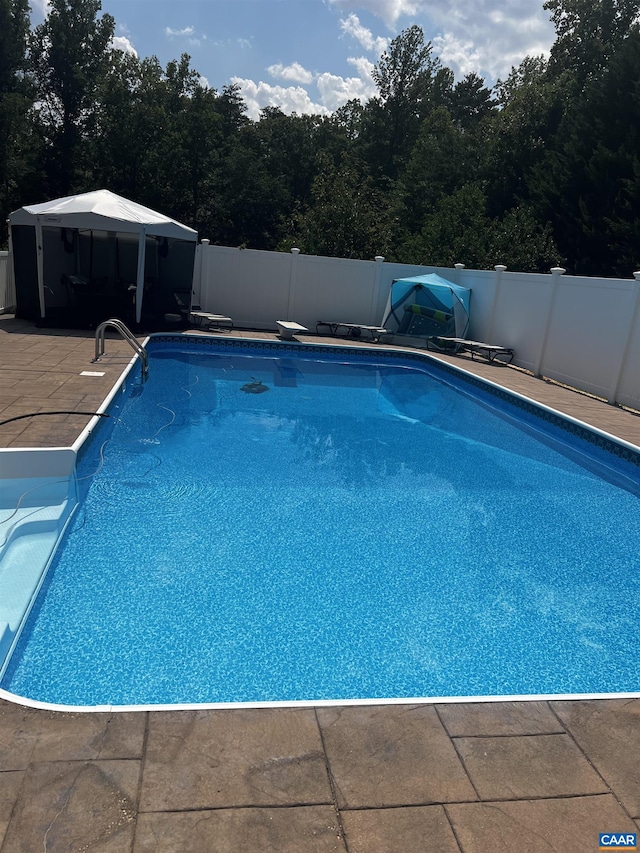 view of swimming pool featuring a gazebo, a patio area, a fenced in pool, and fence