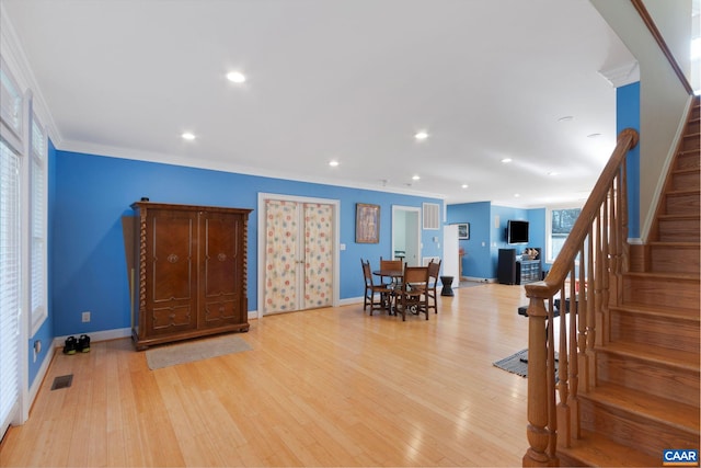 interior space with stairs, ornamental molding, recessed lighting, light wood finished floors, and baseboards