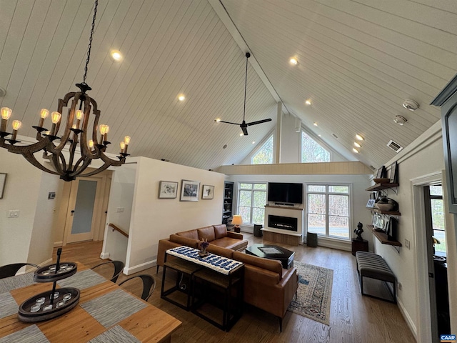 living area featuring an inviting chandelier, high vaulted ceiling, plenty of natural light, and wood finished floors