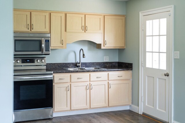 402 Marshall St, Staunton, VA 24401 - kitchen featuring appliances with stainless steel finishes, a sink, light brown cabinets, dark wood finished floors, and dark stone counters