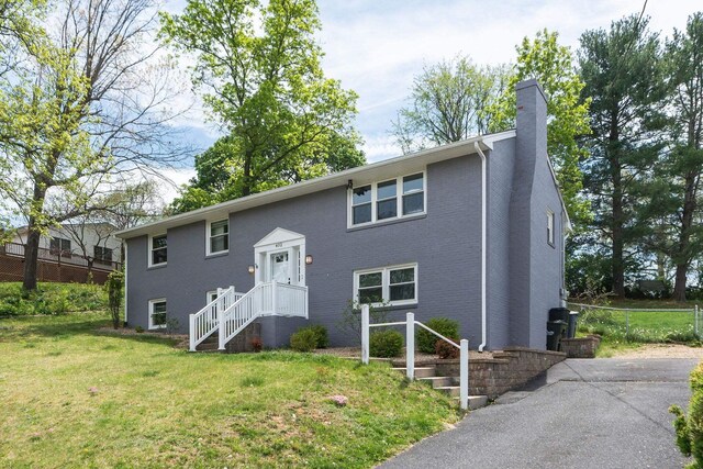 402 Marshall St, Staunton, VA 24401 - split foyer home featuring a chimney, a front yard, and brick siding