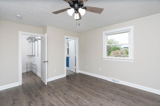 402 Marshall St, Staunton, VA 24401 - unfurnished bedroom featuring dark wood finished floors, baseboards, a ceiling fan, a textured ceiling, and connected bathroom