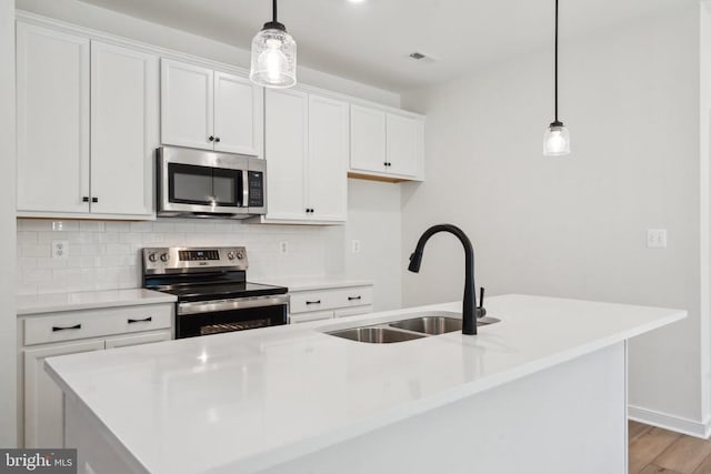 405 Richmond Ave, Mineral, VA 23117 - kitchen featuring stainless steel appliances, decorative backsplash, white cabinetry, a center island with sink, and light countertops