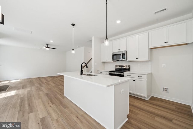 405 Richmond Ave, Mineral, VA 23117 - kitchen with stainless steel appliances, tasteful backsplash, light wood-style flooring, a ceiling fan, and white cabinets