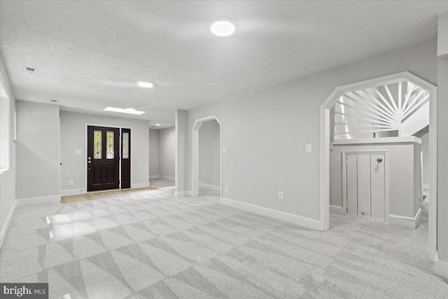 3050 Patriot Ln, Fredericksburg, VA 22408 - foyer entrance with light colored carpet, arched walkways, and a textured ceiling
