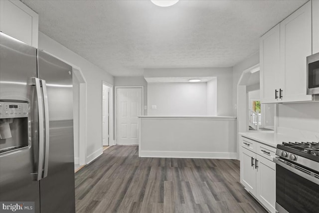 3050 Patriot Ln, Fredericksburg, VA 22408 - kitchen with stainless steel appliances, white cabinets, light countertops, dark wood-style floors, and a textured ceiling