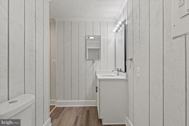 3050 Patriot Ln, Fredericksburg, VA 22408 - bathroom with wood finished floors, vanity, ornamental molding, a textured ceiling, and wood walls