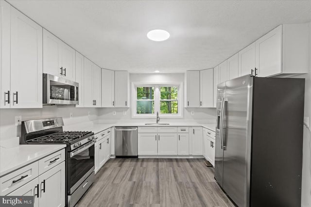 3050 Patriot Ln, Fredericksburg, VA 22408 - kitchen featuring stainless steel appliances, light wood-style flooring, white cabinetry, and light countertops