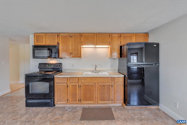 3340 James River Rd, Howardsville, VA 24562 - kitchen with a sink, a textured ceiling, baseboards, black appliances, and light countertops