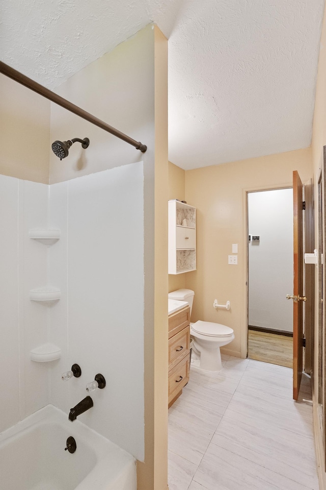 full bath featuring a textured ceiling, vanity, toilet, bathing tub / shower combination, and tile patterned floors
