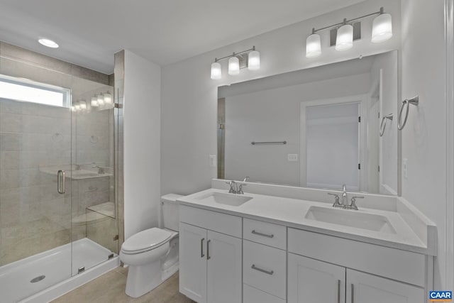 full bath featuring toilet, double vanity, a sink, and a shower stall