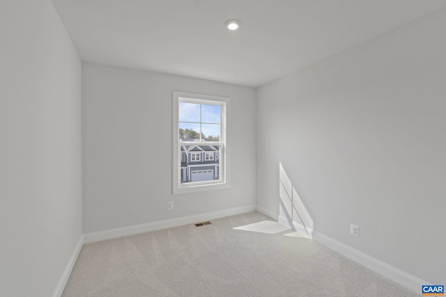 carpeted empty room with visible vents, baseboards, and recessed lighting