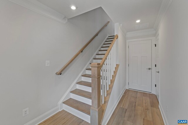stairway with baseboards, recessed lighting, crown molding, and wood finished floors