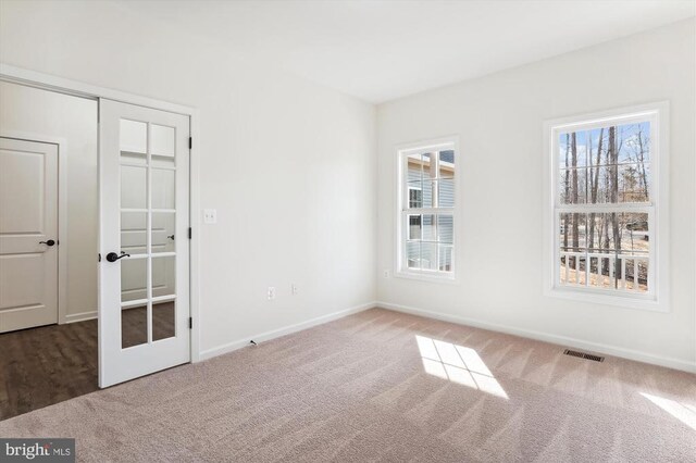  - empty room featuring carpet flooring, baseboards, and french doors