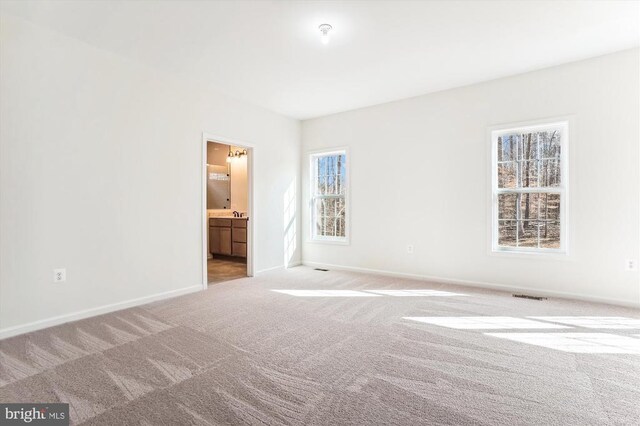  - empty room with light colored carpet and baseboards