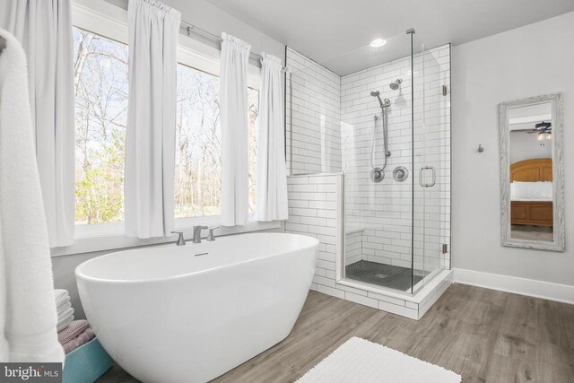 105 Chesterfield Ct, Locust Grove, VA 22508 - bathroom featuring a shower stall, a soaking tub, wood finished floors, and baseboards