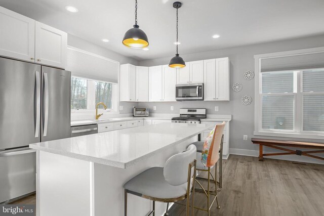105 Chesterfield Ct, Locust Grove, VA 22508 - kitchen featuring stainless steel appliances, light wood-type flooring, baseboards, a center island, and decorative light fixtures