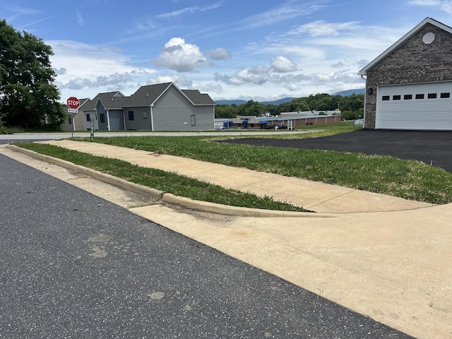 81 Meriwether Cir, Stuarts Draft, VA 24477 - view of property exterior featuring a mountain view, a garage, brick siding, asphalt driveway, and a yard