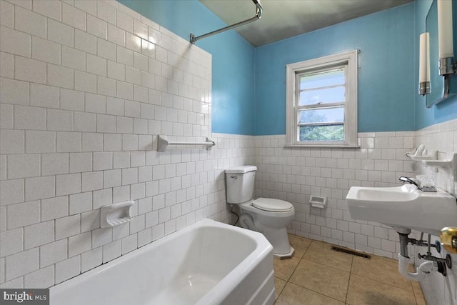 4970 Ridge Rd, Spotsylvania, VA 22551 - bathroom with a tub, tile patterned flooring, tile walls, and wainscoting