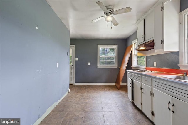 4970 Ridge Rd, Spotsylvania, VA 22551 - kitchen with under cabinet range hood, white cabinetry, a ceiling fan, gas stovetop, and light countertops