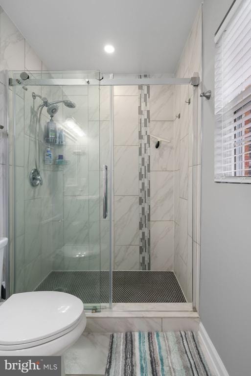 11104 Piney Forest Rd, Bumpass, VA 23024 - bathroom featuring toilet, marble look tiles, and a stall shower
