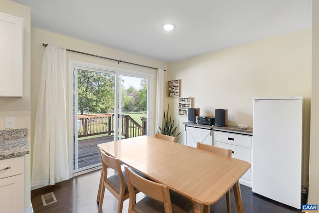 dining room with dark wood-style flooring and recessed lighting