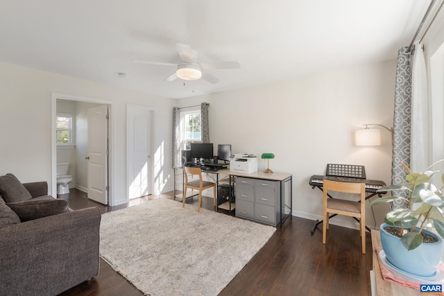 office area with dark wood finished floors, plenty of natural light, a ceiling fan, and baseboards