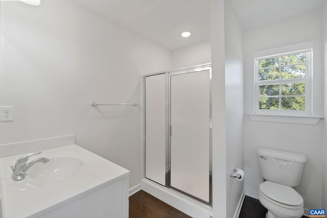 full bathroom featuring a shower stall, toilet, wood finished floors, baseboards, and vanity