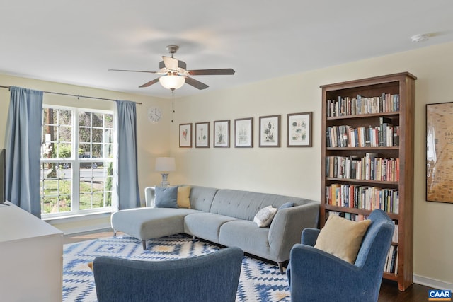 living area featuring ceiling fan and dark wood-style floors