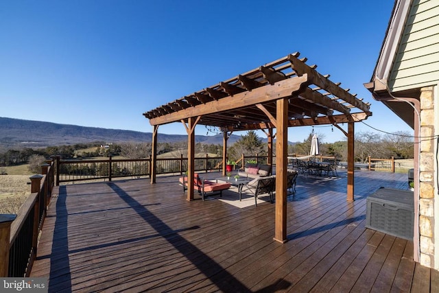 deck with a pergola, an outdoor hangout area, a mountain view, and outdoor dining space