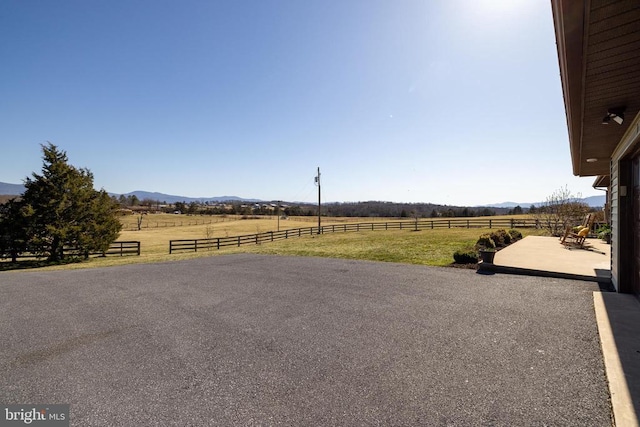 view of yard featuring a view of rural / pastoral area, a mountain view, and a patio