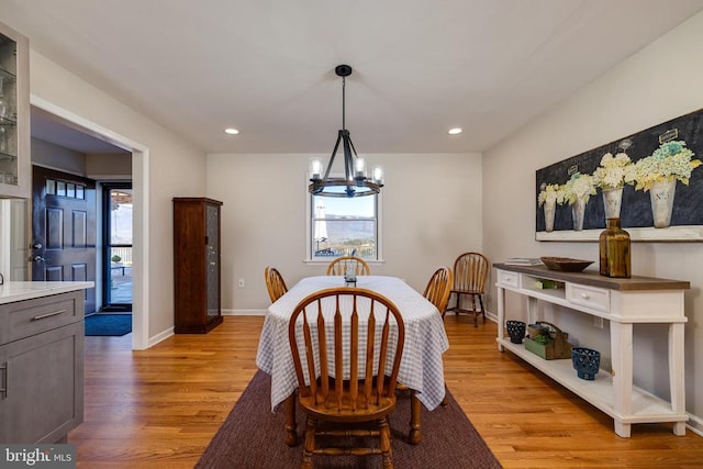 dining area with light wood finished floors, a chandelier, baseboards, and recessed lighting