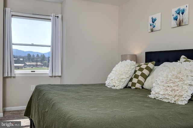 bedroom featuring baseboards, carpet flooring, and a mountain view