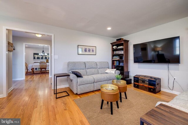 living area with light wood-style flooring, baseboards, a chandelier, and recessed lighting
