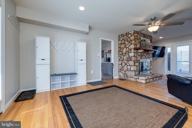 unfurnished living room featuring wood finished floors, a ceiling fan, a fireplace, baseboards, and recessed lighting