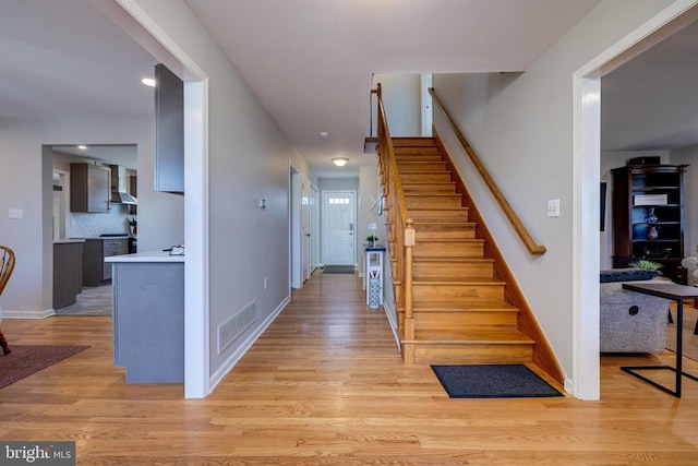 stairway with wood finished floors and baseboards