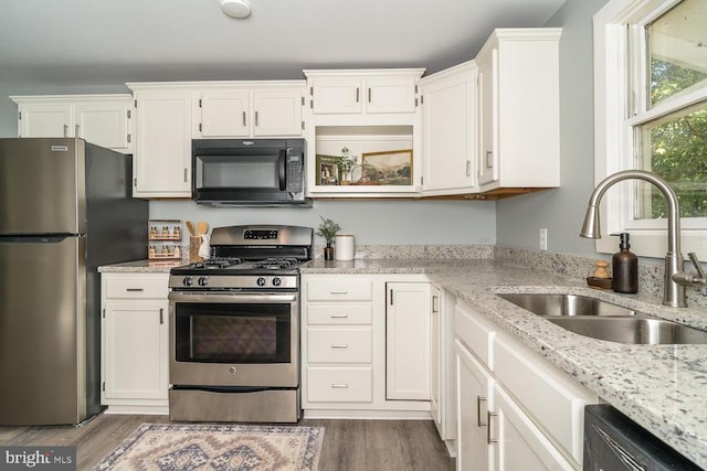 1055 Hacktown Rd, Keswick, VA 22947 - kitchen with appliances with stainless steel finishes, a sink, white cabinetry, light stone countertops, and wood finished floors