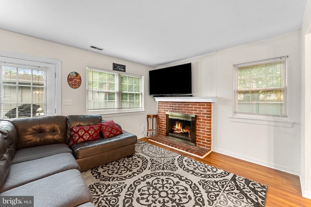 133 Woodlake Dr, Charlottesville, VA 22901 - living area featuring wood finished floors, a brick fireplace, and plenty of natural light
