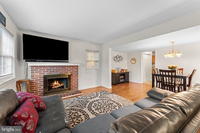 133 Woodlake Dr, Charlottesville, VA 22901 - living area with light wood finished floors, a chandelier, a fireplace, and baseboards