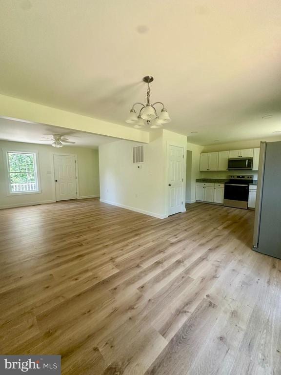 6273 Tatum Rd, Culpeper, VA 22701 - unfurnished living room with a chandelier, light wood-type flooring, baseboards, and a ceiling fan