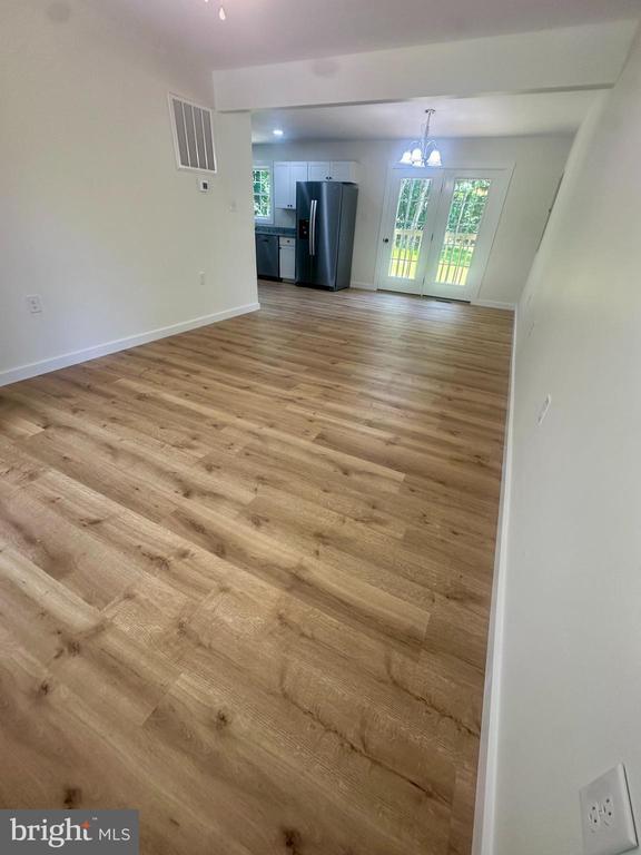 6273 Tatum Rd, Culpeper, VA 22701 - unfurnished living room with light wood-type flooring, a chandelier, and baseboards