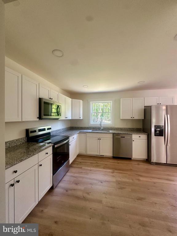 6273 Tatum Rd, Culpeper, VA 22701 - kitchen featuring stainless steel appliances, a sink, white cabinetry, light wood finished floors, and recessed lighting