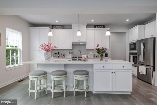 11316 Oakville Ln, Spotsylvania, VA 22551 - kitchen featuring appliances with stainless steel finishes, under cabinet range hood, white cabinetry, dark wood-style flooring, and light countertops