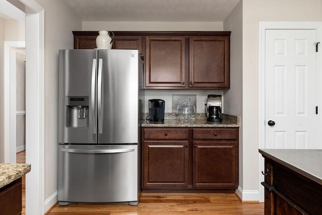 15 Devonshire Ct, Fishersville, VA 22939 - kitchen featuring stainless steel fridge, light wood-style flooring, dark brown cabinets, baseboards, and light stone counters
