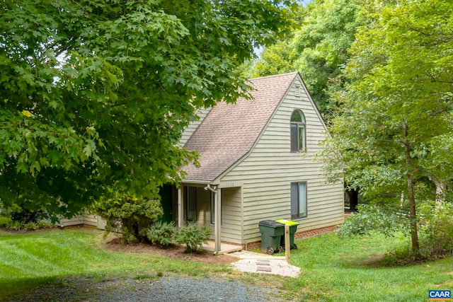 rear view of property with a yard and a shingled roof