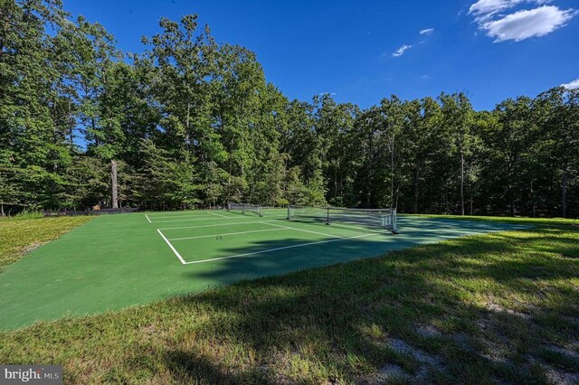 299 Sunset Loop, Mineral, VA 23117 - view of tennis court featuring a wooded view and a lawn