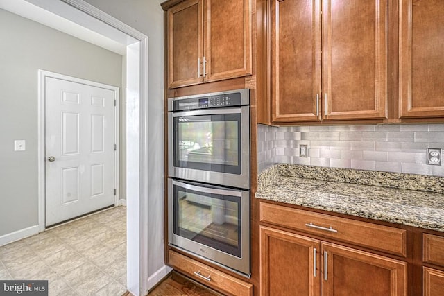 299 Sunset Loop, Mineral, VA 23117 - kitchen featuring double oven, baseboards, light stone counters, decorative backsplash, and brown cabinetry