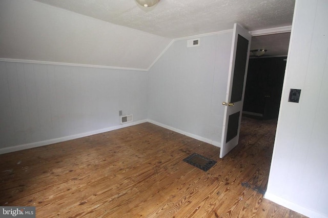  - additional living space with wood finished floors, lofted ceiling, and a textured ceiling