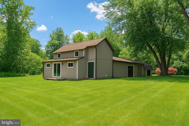 - rear view of property featuring a yard
