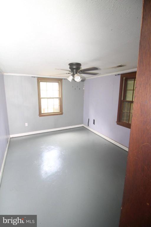  - empty room with finished concrete floors and ceiling fan